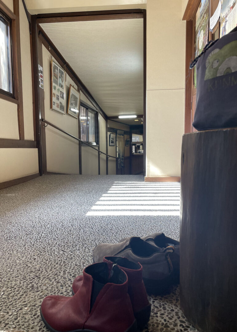 Shoes by hallway entrance with sunlit floor